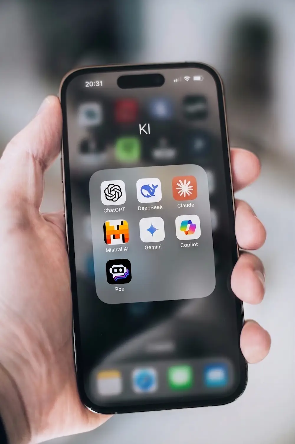 Smartphone mit KI-Apps wie ChatGPT, Gemini, Claude, DeepSeek, Mistral und Copilot in einem Ordner